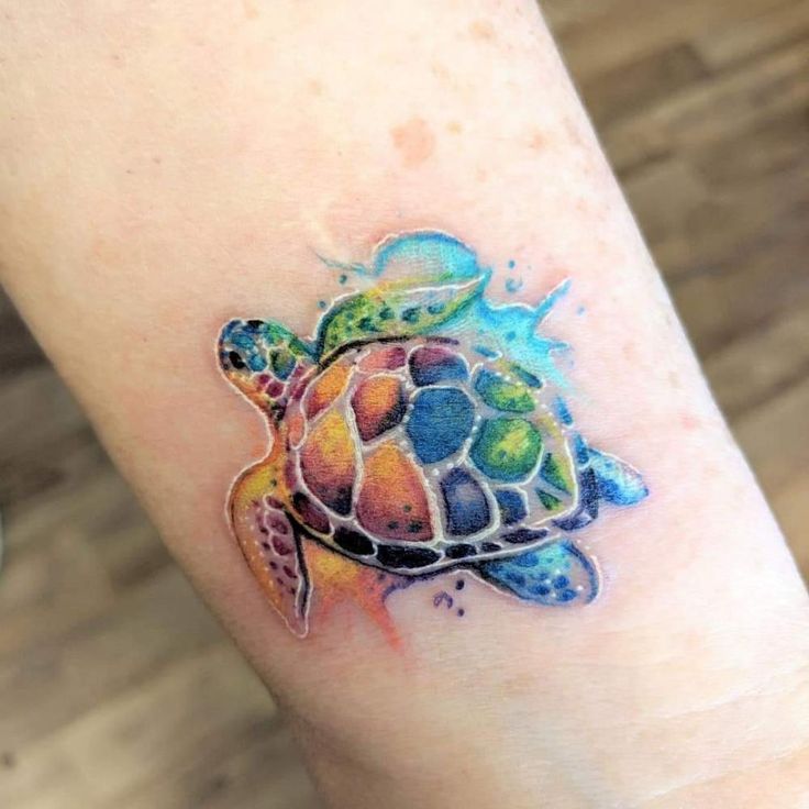 a colorful turtle tattoo on the arm and foot is shown in this image, it looks like