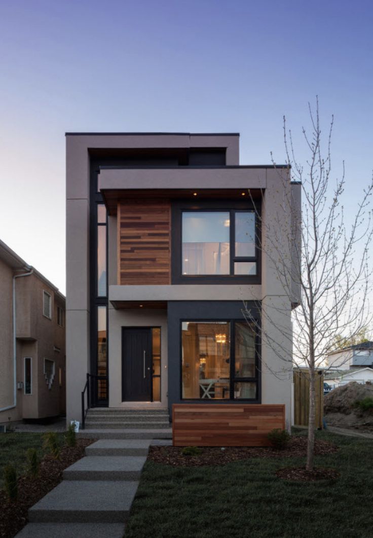 a modern house with two levels and lots of windows