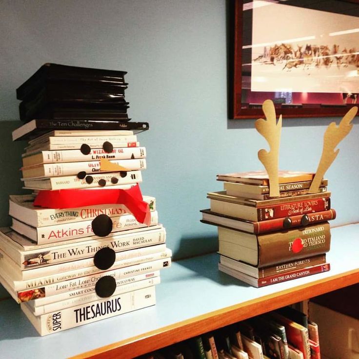 stacks of books are stacked on top of each other in front of a blue wall