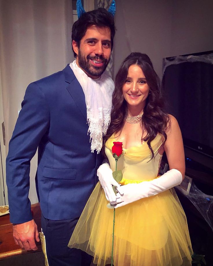 a man in a blue suit and yellow dress standing next to a woman dressed as beauty and the beast