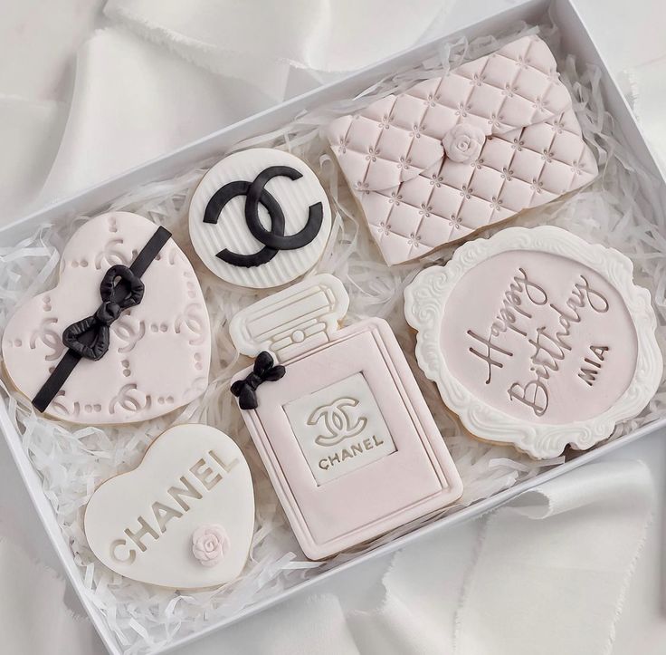 a box filled with decorated cookies in the shape of chanel