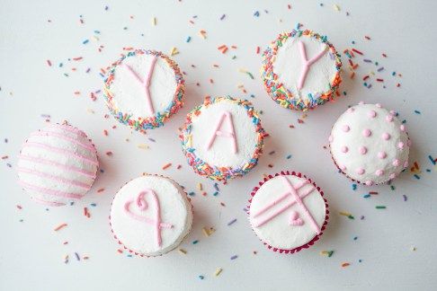 cupcakes with frosting and sprinkles are arranged on a table