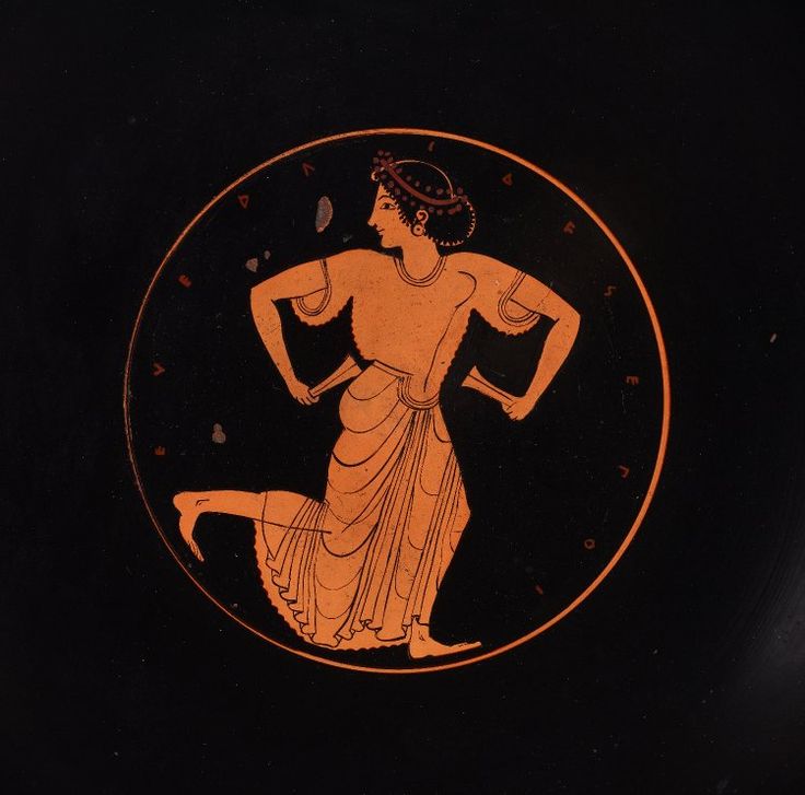 an orange and black greek vase with a woman on it's side, in the center