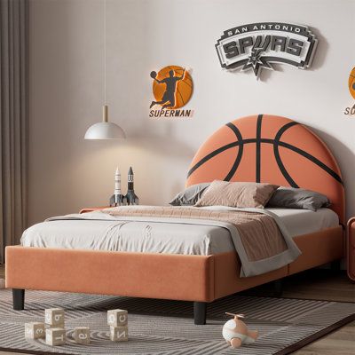 a bed with an orange headboard and basketball decals on the wall