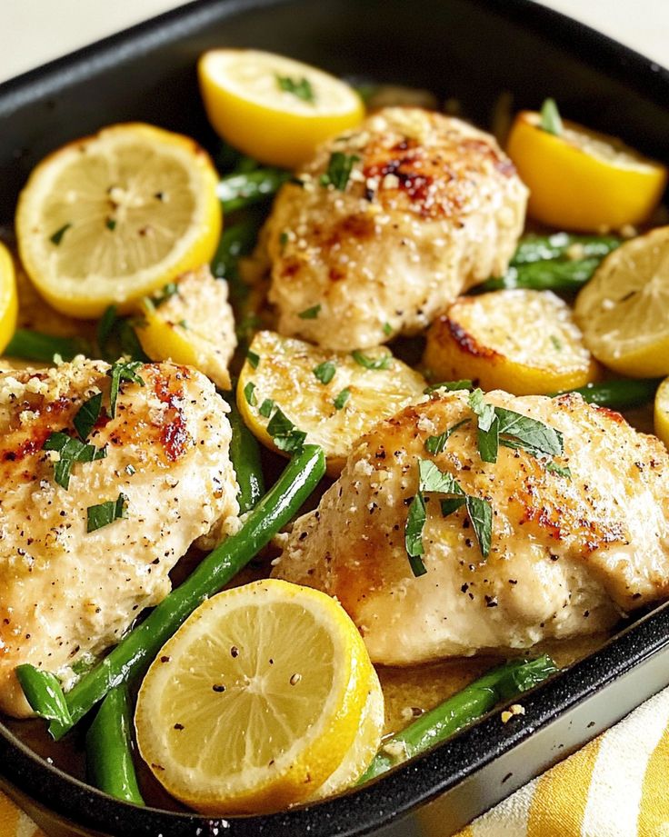 a pan filled with chicken, lemons and green beans