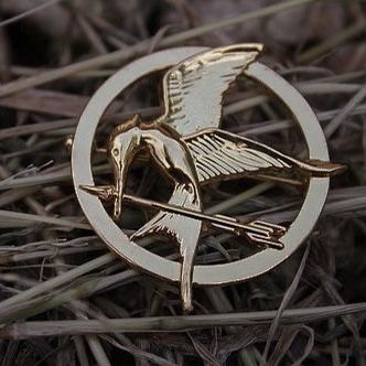 a gold bird pin sitting on top of grass