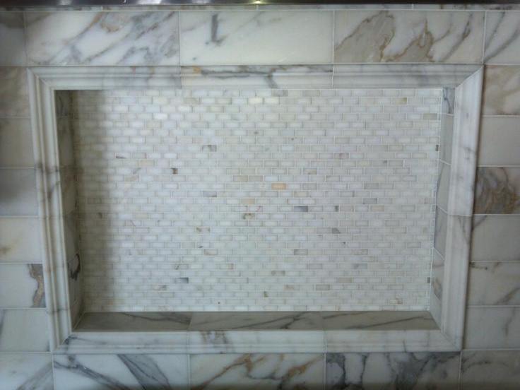 a bathroom with marble tile and white tiling