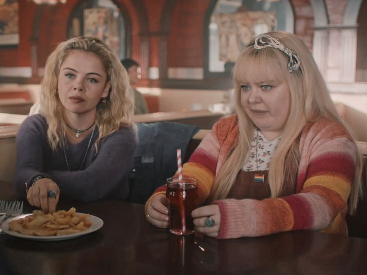 two women sitting at a table eating food