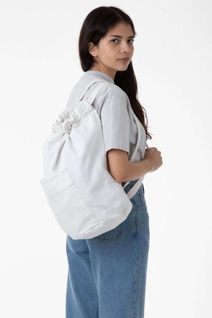 This garment-dyed, bull denim bag has a round-shaped bottom with plenty of height to fill with taller items. It is designed like a backpack with two straps that double also function as a drawstring to keep your belongings safe. We've also added a front pocket for easy access. Our bags are made in our in house factory in Los Angeles, California by workers earning a living wage. Each bag is manufactured and then dyed in batches, giving the thick textile of the bag a weathered texture. These bags c Casual Large Capacity Drawstring Shoulder Bag, Casual Large Capacity Shoulder Drawstring Bag, Functional Cotton Softback Bag, Casual Large Capacity Drawstring Bag, Daily Use Cotton Shoulder Backpack, Cotton Shoulder Bag Backpack For Daily Use, Casual Bucket Bag With Adjustable Strap For School, Everyday Large Capacity Drawstring Backpack, Everyday Cotton Canvas Bag With Adjustable Straps