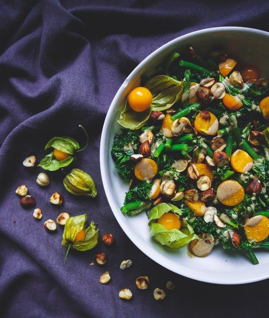 a white bowl filled with vegetables and nuts