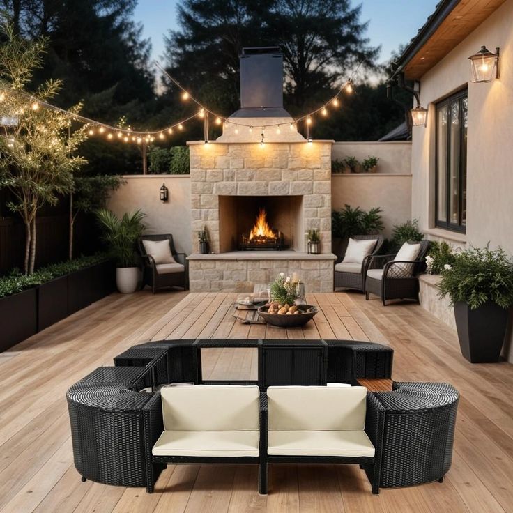 an outdoor fireplace and seating area with lights strung over it's sides, surrounded by wood flooring