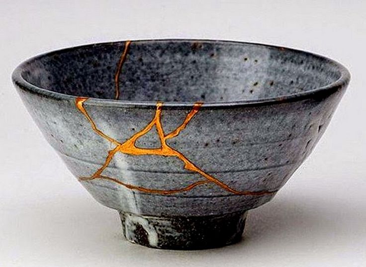 a black and orange bowl sitting on top of a white table