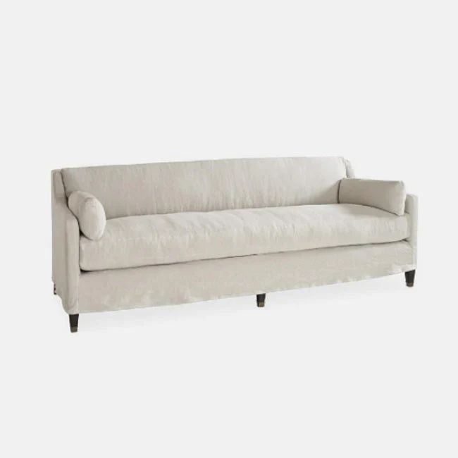 a white couch sitting on top of a wooden floor next to a gray wall in front of it