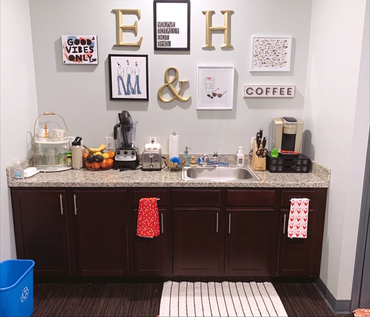 a kitchen with brown cabinets and pictures on the wall above it's counter top