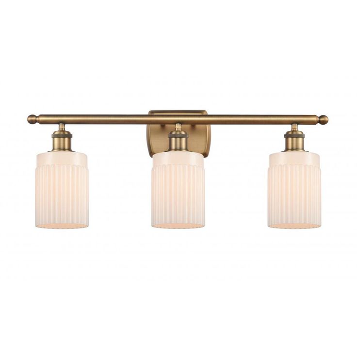 three light bathroom fixture in an antique brass finish with frosted glass shades and gold accents