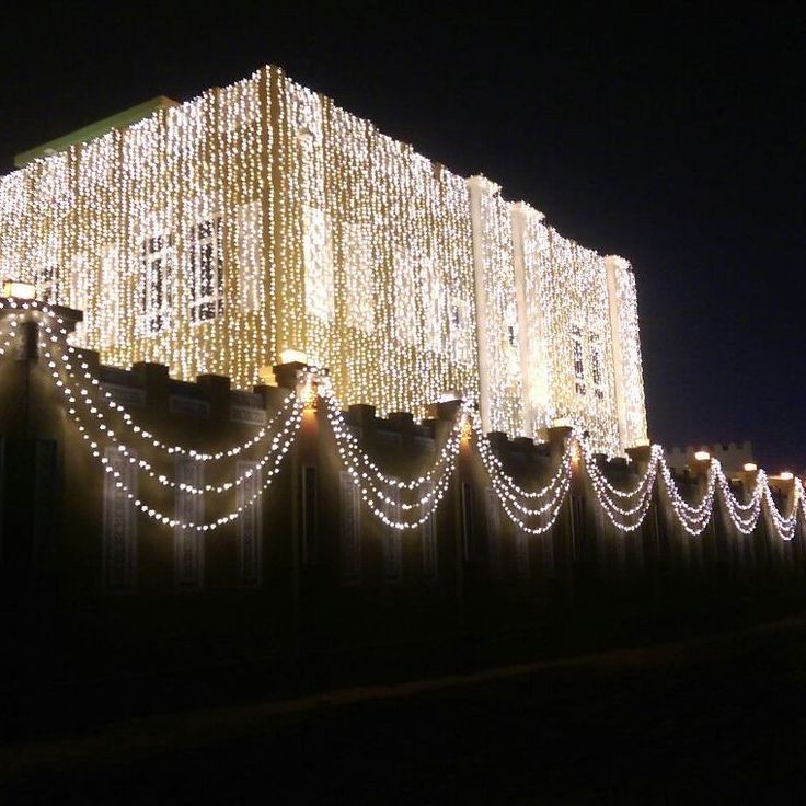 a large building covered in christmas lights and garlands on top of it's sides