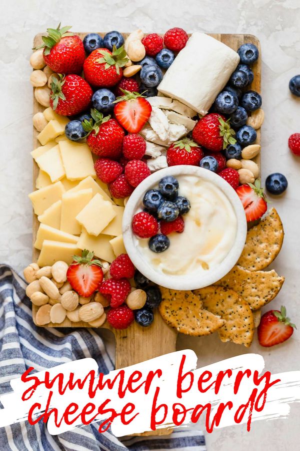 a cheese board with strawberries, blueberries, and crackers on it that says summer berry cheese board