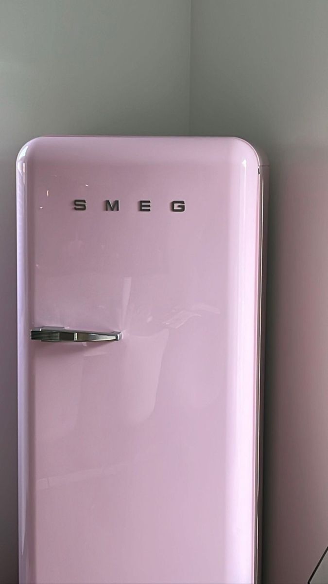 a pink refrigerator with the word smed on it's door is next to a white wall