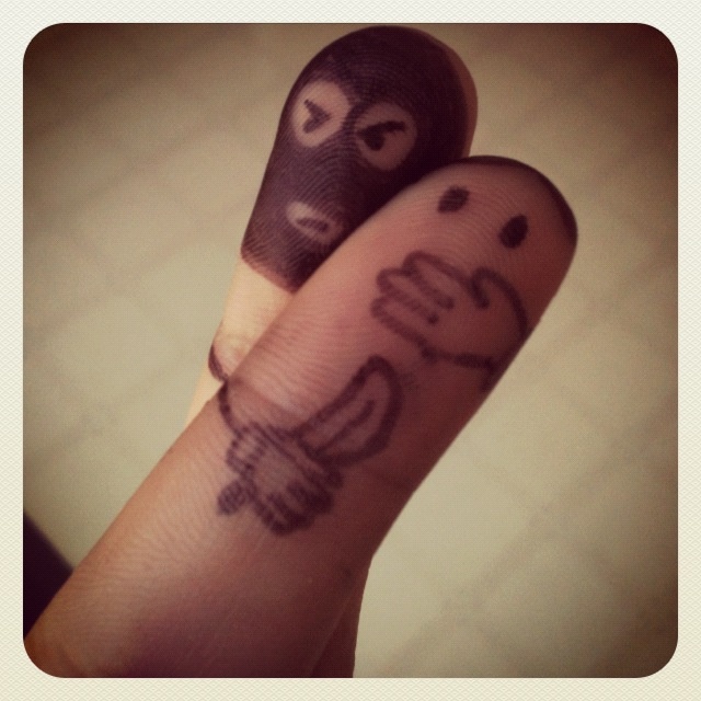 two fingers with faces drawn on them, one is holding the other's finger