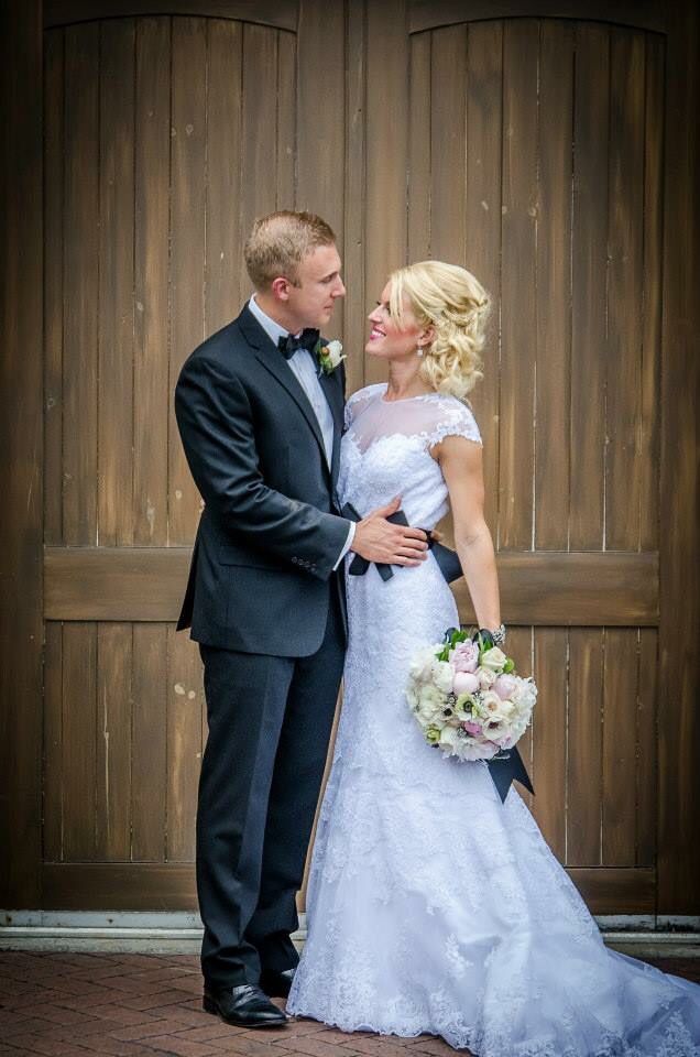 a bride and groom standing in front of a wooden door