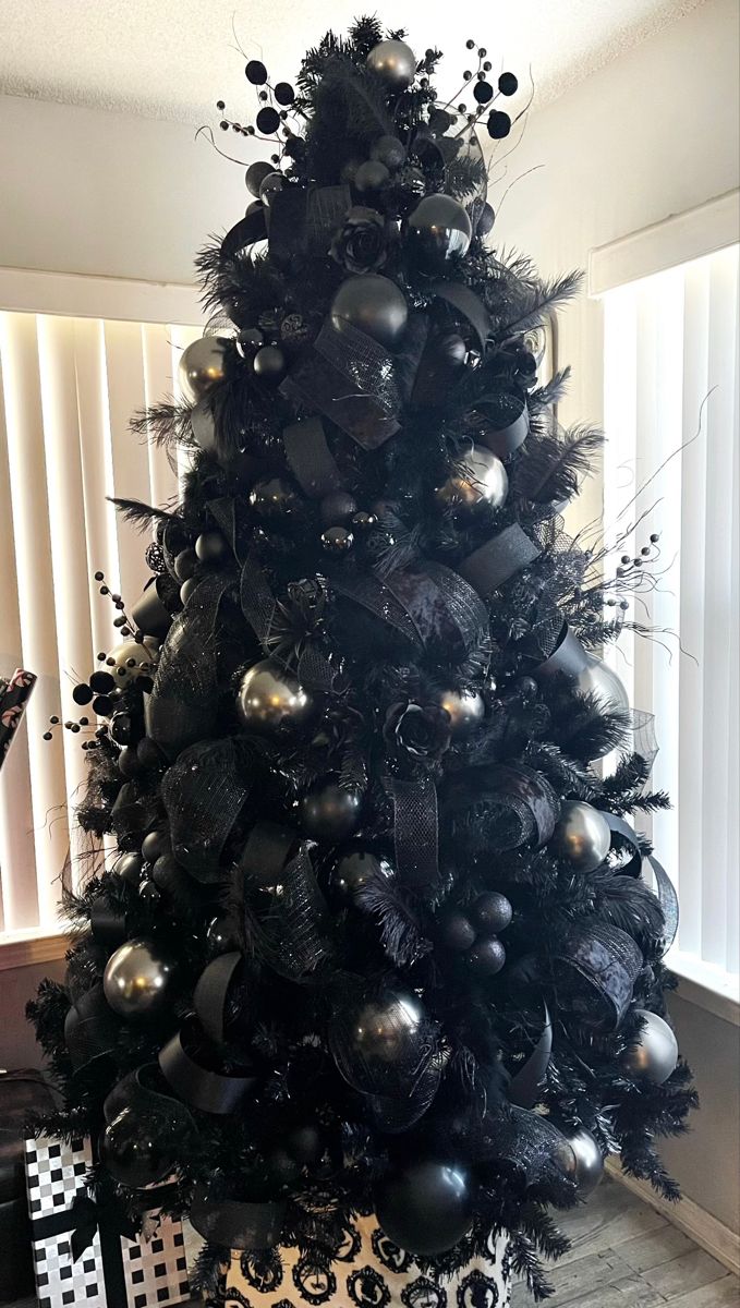 a black christmas tree decorated with silver ornaments