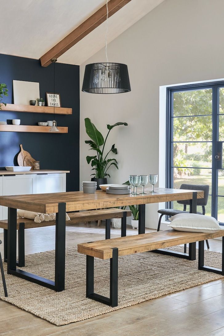 a dining room table with two benches next to it