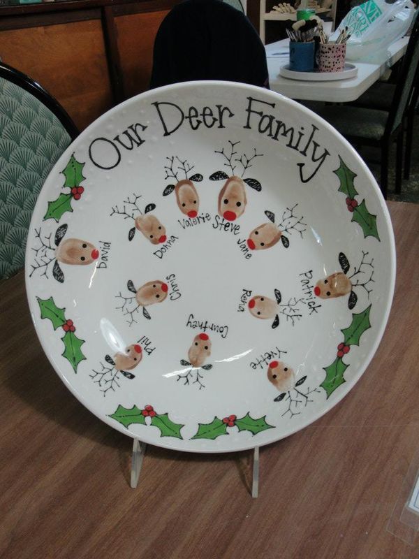 a white plate decorated with dogs and holly wreaths on the bottom says our deer family