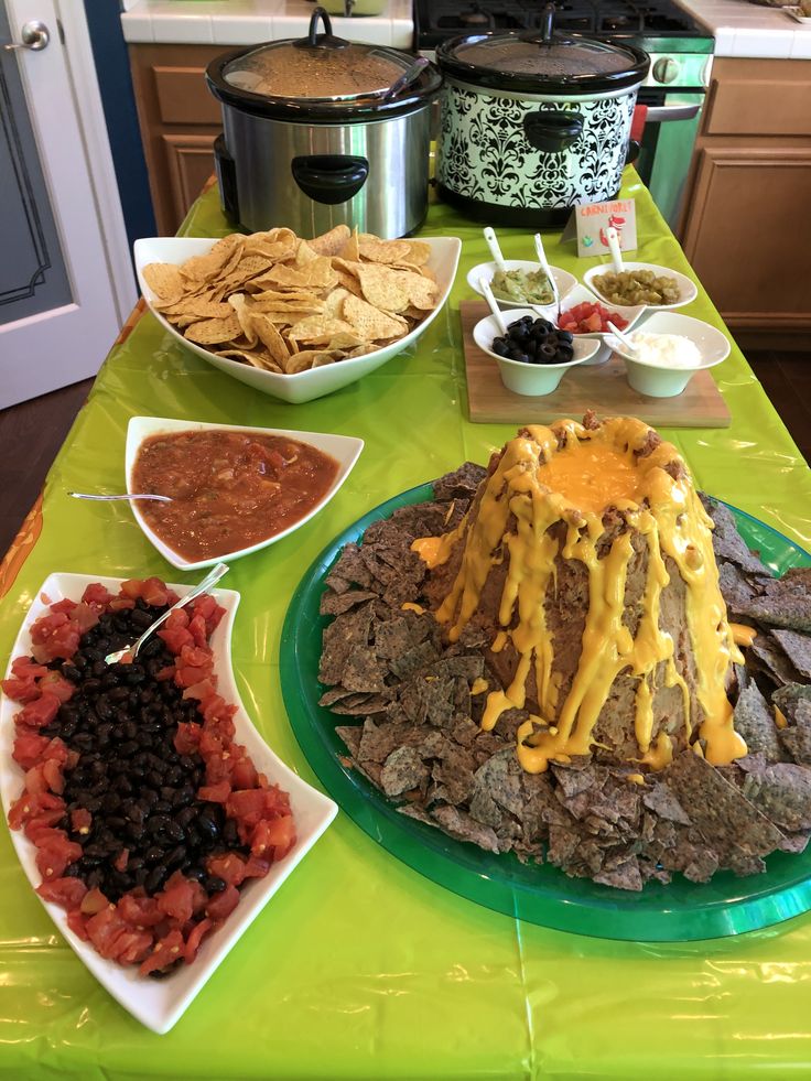 a green table topped with lots of food and condiments on top of it