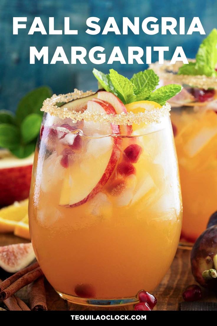 two glasses filled with fruit and garnish on top of a wooden table