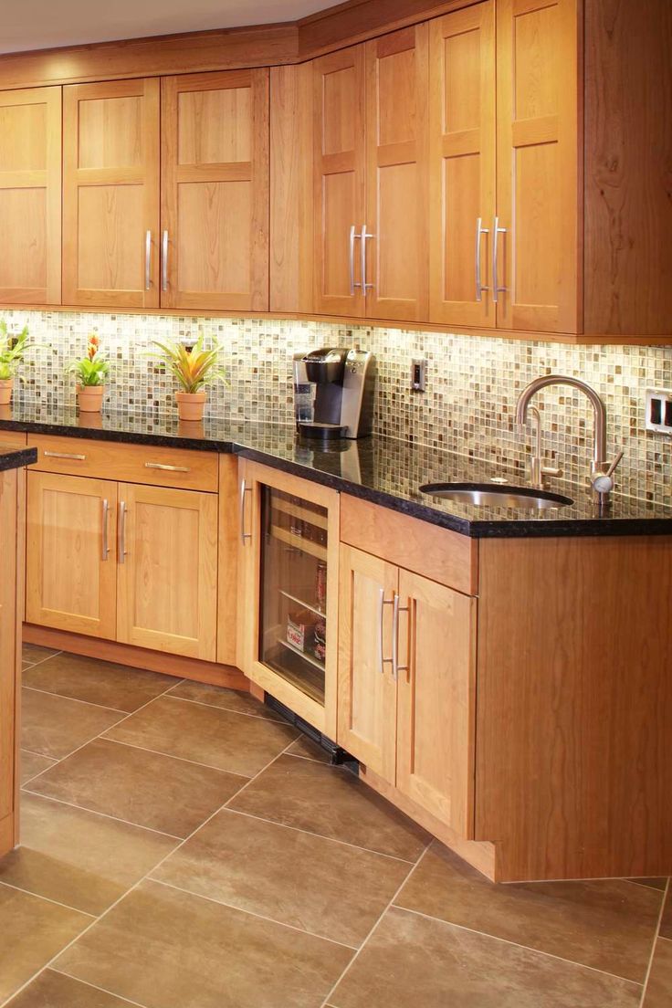 a kitchen with wooden cabinets and black counter tops