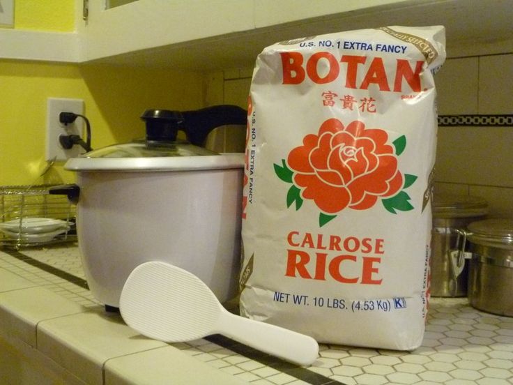 a bag of calrose rice sitting on top of a counter next to a measuring spoon