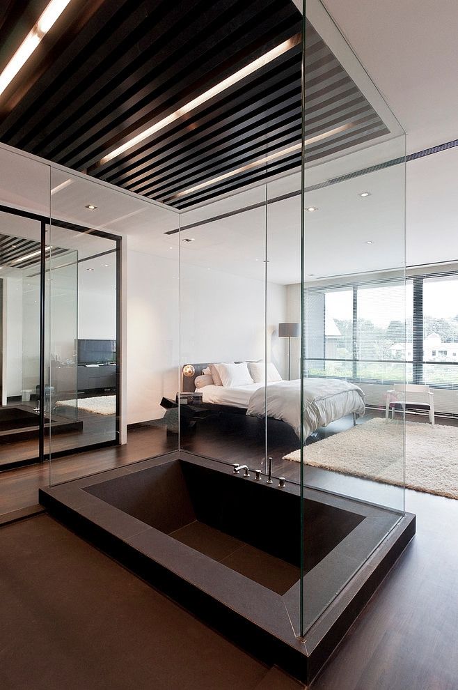 a modern bedroom with glass walls and wood flooring on the ceiling, along with a large bed