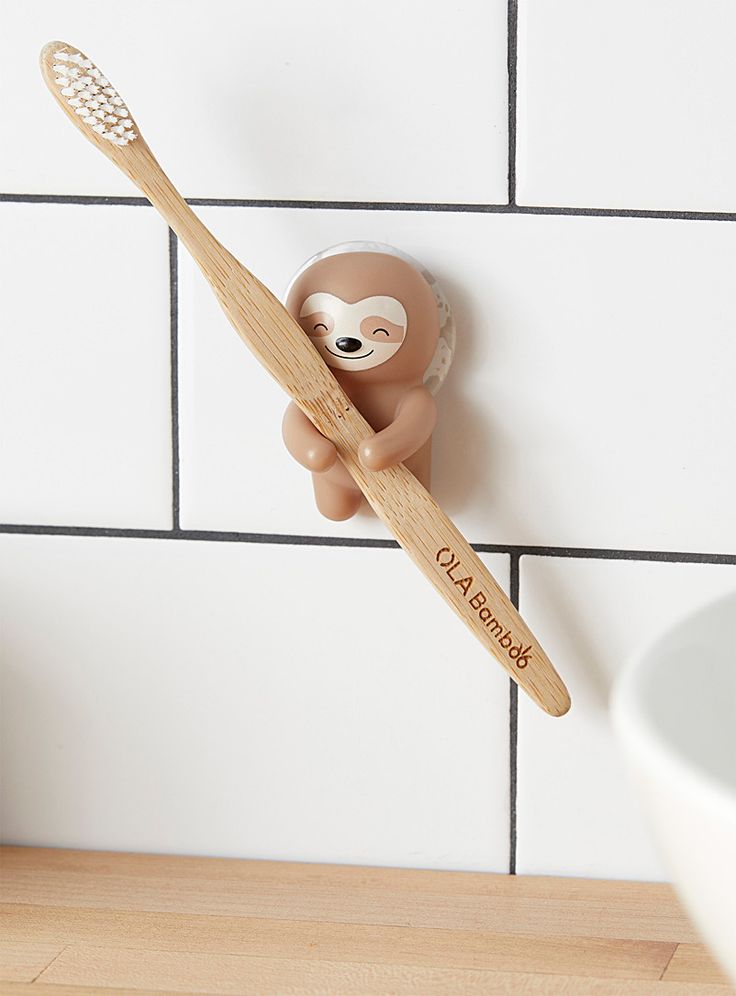 a toothbrush holder with a slotty bear on it's side hanging from the wall