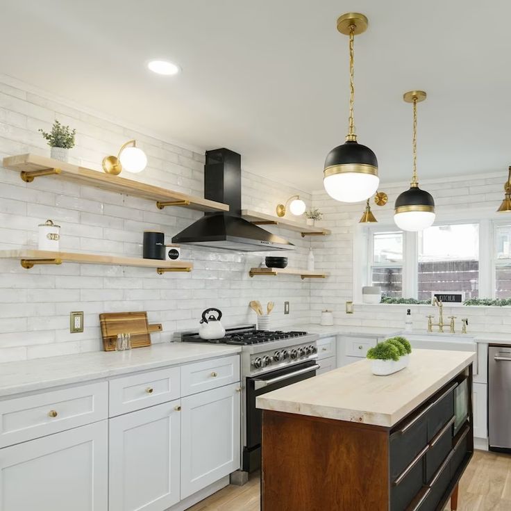 a kitchen with white cabinets and gold accents on the ceiling, along with an island in the middle