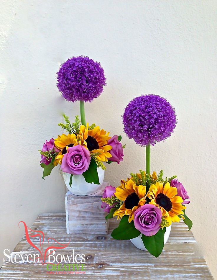 two vases filled with purple and yellow flowers