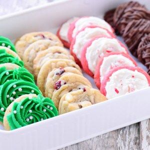 an assortment of decorated cookies in a white box