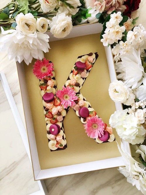 the letter k is surrounded by flowers