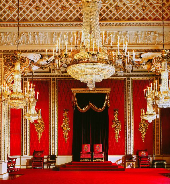 an ornate room with chandeliers and red carpet