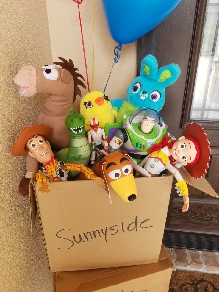 a cardboard box filled with toys and balloons on top of a door sill next to a sign that says sunnyside