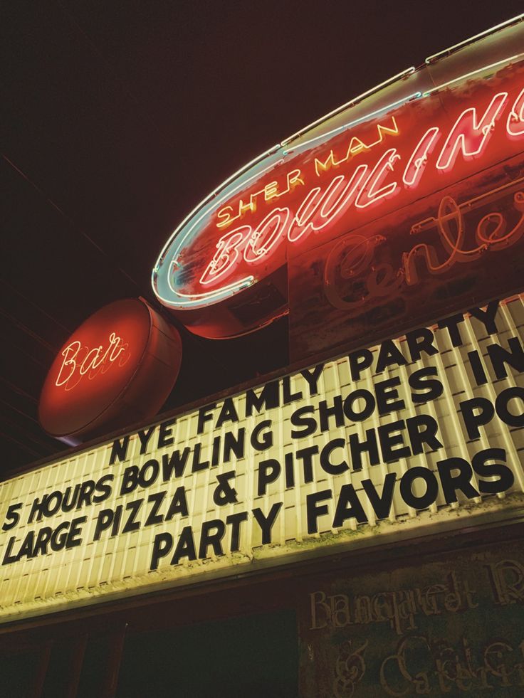 a neon sign for a bowling bar and party venue in the dark with no one around it