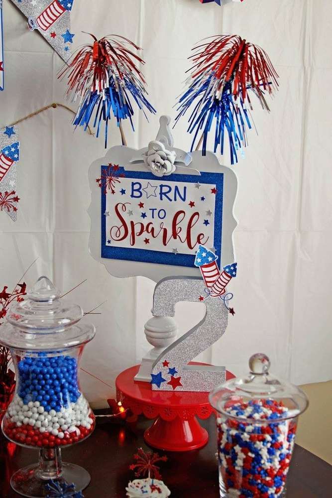 a table topped with red, white and blue candy bar items next to a sign that says born to sparkle