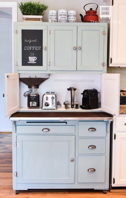 an old fashioned kitchen with blue cabinets and white cupboards, coffee maker on the counter