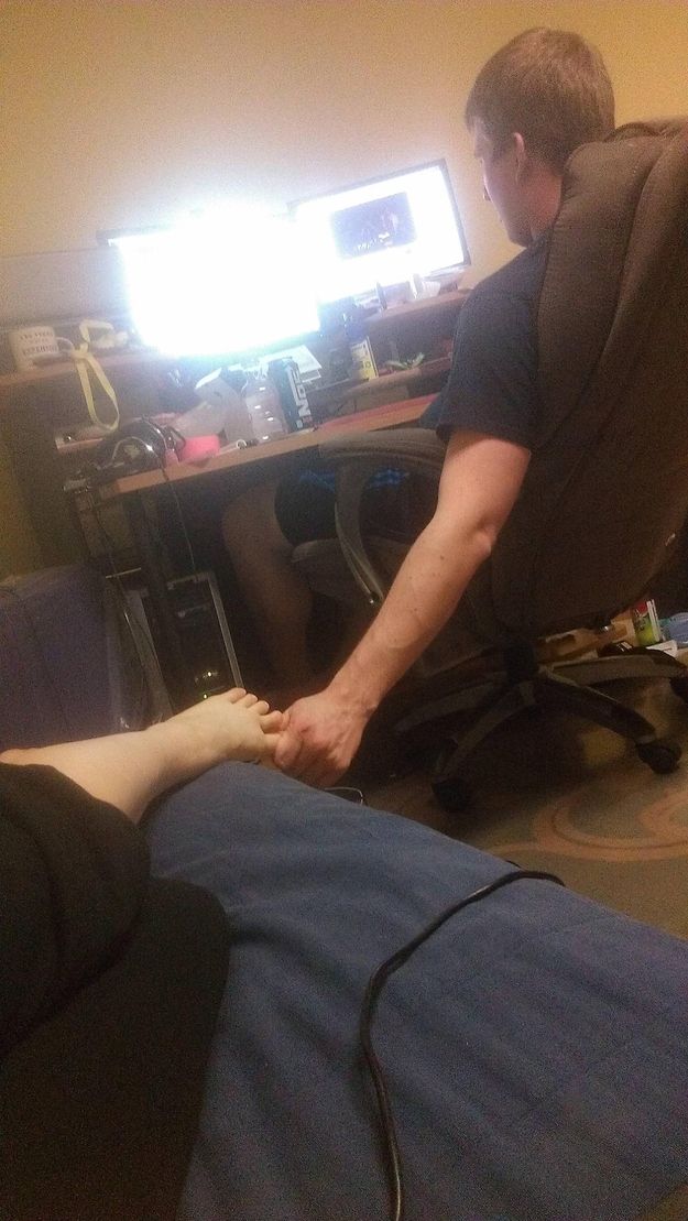 a man sitting in a chair with his foot up on the computer desk next to him