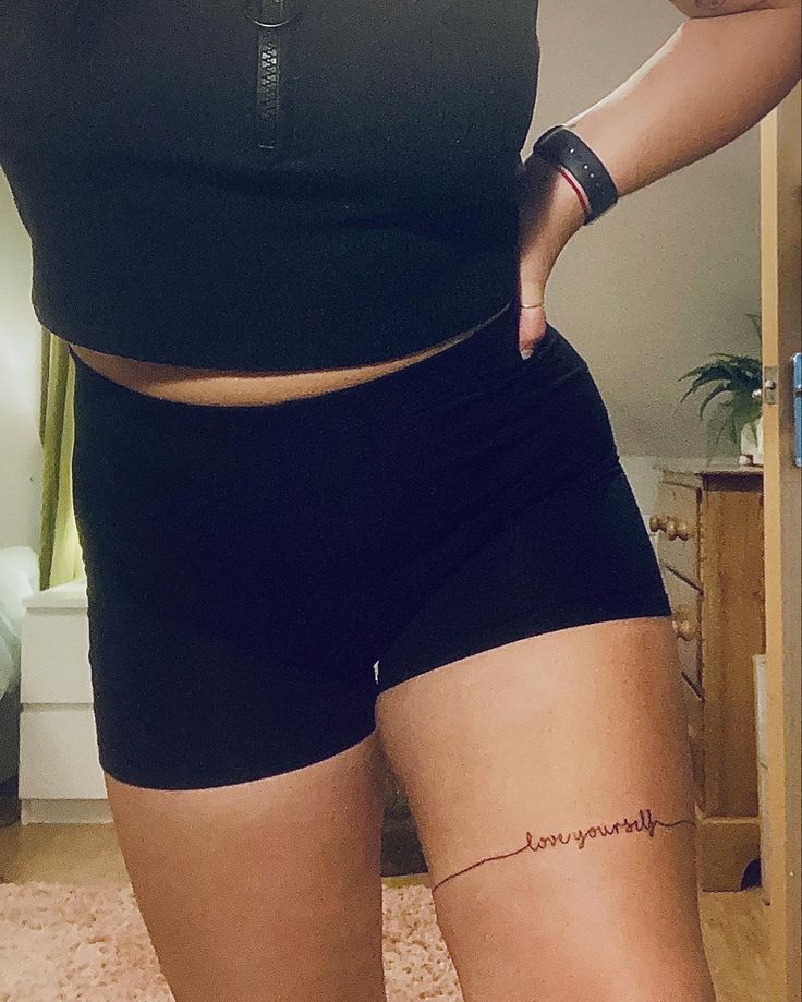 a woman in black shorts and a tattoo on her stomach