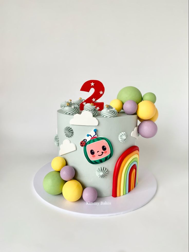 a birthday cake decorated with rainbows and clouds