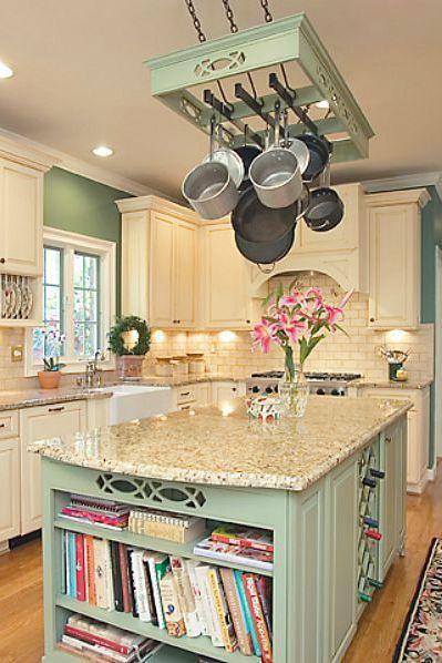 a kitchen island with pots and pans hanging from the ceiling