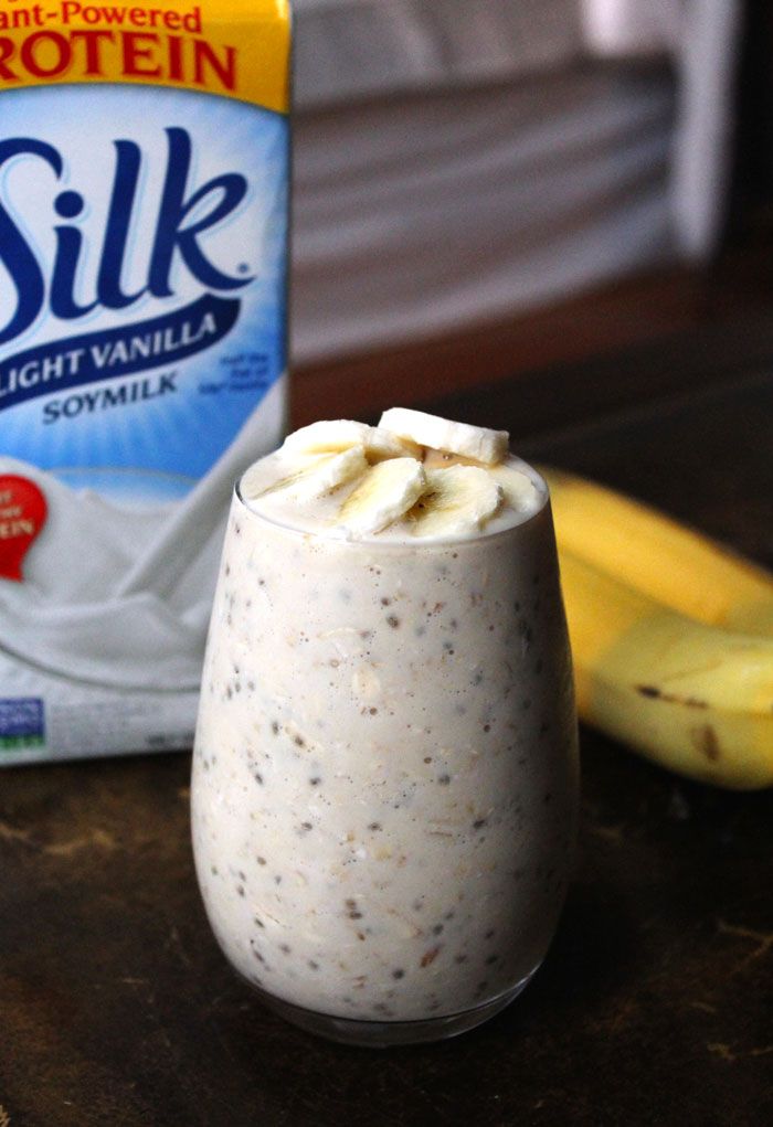 a banana and yogurt smoothie in a glass next to a carton of milk