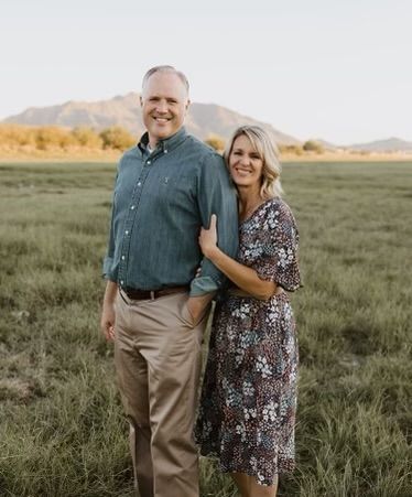 a man and woman standing in the middle of a field