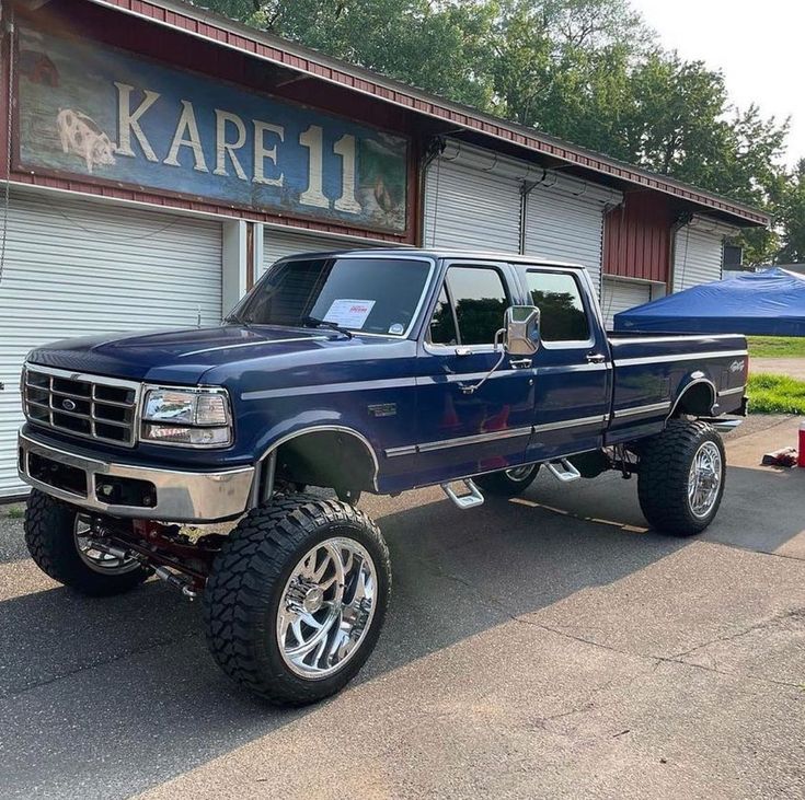 a blue pick up truck parked in front of a building