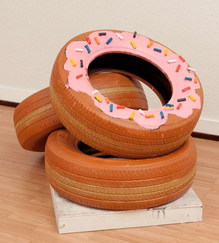 two wooden tires stacked on top of each other with pink frosting and sprinkles